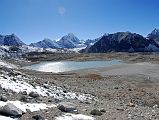 10 25 Baruntse Base Camp Beyond Lake With Hongu Peak, Eastern End Of Malanphulan, Ama Dablam From the bottom of the West Col, it was all downhill, first on the glacier, then on muddy rocks towards Baruntse Base Camp (5450m) next to a lake, with Hongu Peak on the far left, the eastern end of Malanphulan in the centre, and Ombigaichen and Ama Dablam to the far right.